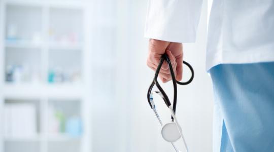 Doctor with stethoscope in a hospital, back view